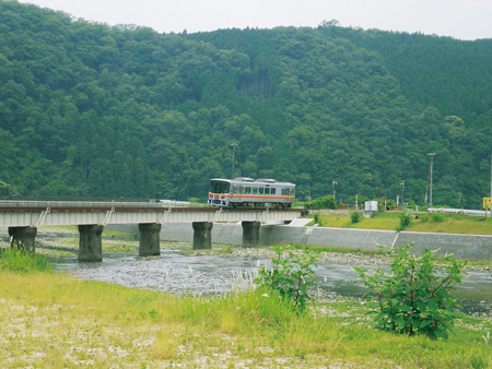以高仓山为背景，铁路姬新线的火车驶过佐用川